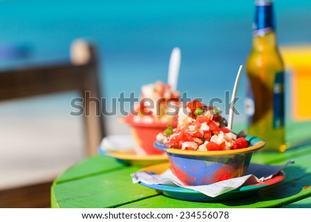 Two bowls of Bahamian conch salad and bottle of beer