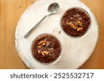 Two bowls of chia seed, chocolate and orange pudding. Healthy snack, wooden background. Top view.