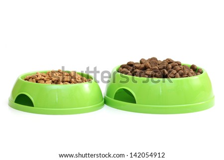 Two bowls with dry food for dog or cat isolated on white background