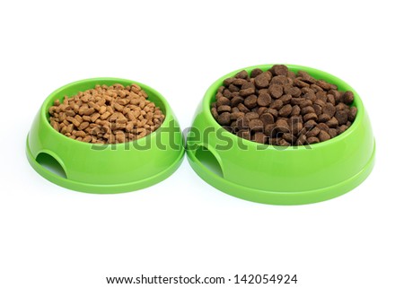 Two bowls with dry food for dog or cat isolated on white background