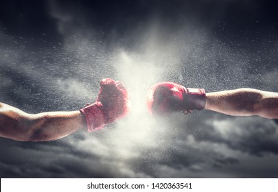 Two boxing gloves punch. Light on cloudy sky. Box, power, fight symbols. - Shutterstock ID 1420363541