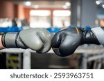 Two boxing gloves touching before a sparring match in a boxing gym, symbolizing sportsmanship and competition