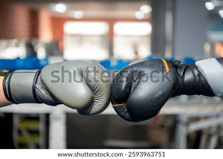 Two boxing gloves touching before a sparring match in a boxing gym, symbolizing sportsmanship and competition