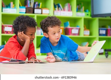 Two boy kid lay down on floor and reading tale book  in preschool library,Kindergarten school education concept - Shutterstock ID 691383946