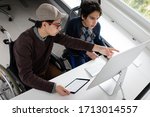 Two boy sitting and using computer
