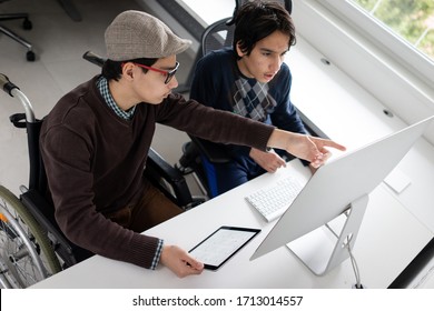 Two boy sitting and using computer