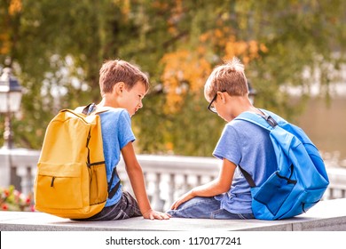 Two Boys After School, Sitting On Bench And Talking