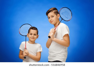 The two boys with badminton rackets outdoors