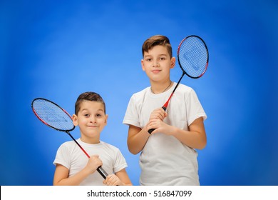 The two boys with badminton rackets outdoors
