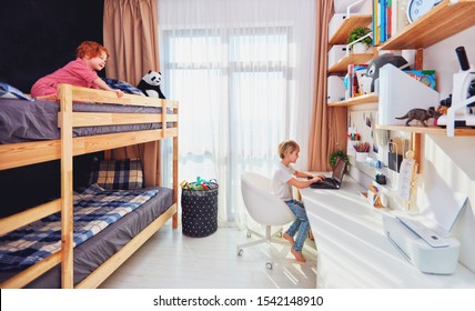 Two Boys, Brothers In Kids Room With Bunk Bed And Wall Shelves