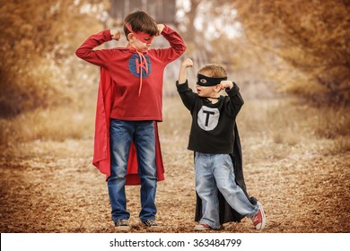 Two Boys Dressed As Superheroes Compare Their Power In The Playground Summer Day