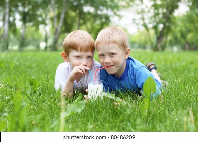 Two Boys Drinking Milk In The Summer Outdoors