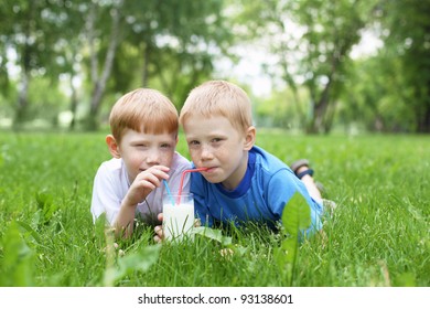 Two Boys Drinking Milk In The Summer Outdoors