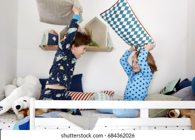 Two Boys Having A Pillow Fight In A Bunk Bed


