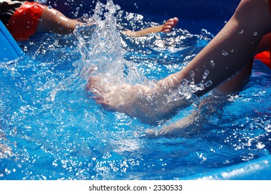 Two Boys Kicking In A Kiddie Pool.