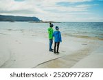 Two boys on Grotlesanden Beach in Storholmen, Norway, at the sea