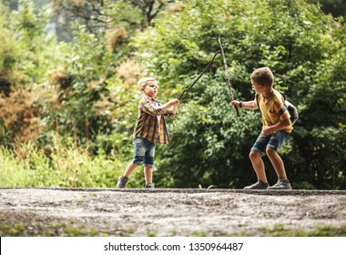 Two boys playing fight with wooden swords.Childhood concept.