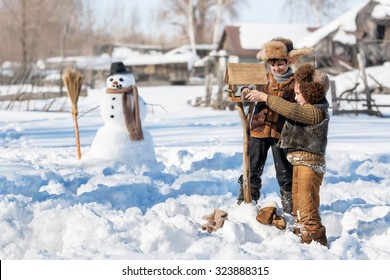 Two Boys Poured Food In A Bird Feeder In The Backyard Of The House Clear Winter Day