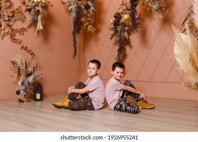 Two Boys In The Same Clothes Sit Back To Back