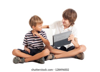 Two Boys Sit On The Floor And Playing Computer Games. Two Brothers, Cute Kids. Studio Shot, Isolated On White Background.