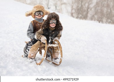 Two boys sledding with mountain warm winter day - Powered by Shutterstock