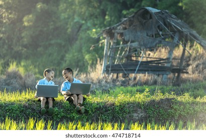 Two Boys Studying By Online Learning With Laptop At Outdoor, Countryside Of Thailand