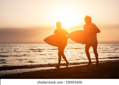 Two Boys With Surf Boards At Sunset