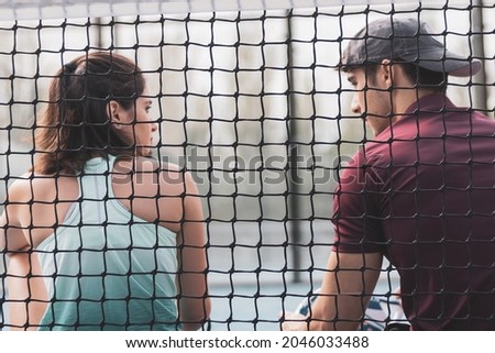 two boys talking after having played a game of paddle tennis.