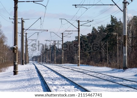Two branches of the electrified railroad stretching into the distance. Electric poles along the railway. Selective focus.  
