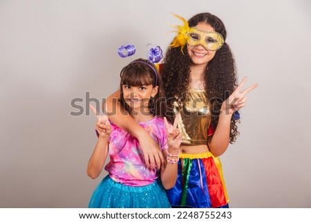 two Brazilian girls friends, dressed in carnival clothes. embraced, posing playing together.