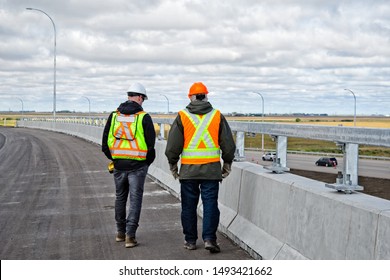 Two bridge engineers conducting a bridge barrier and guard rail inspection.