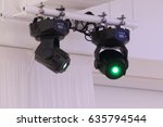Two bright illuminators devices rays of green light in hall during celebration
