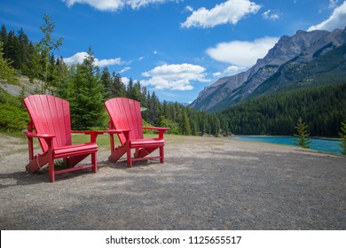 Two bright red Adirondack chairs in Banff National Park, Canada