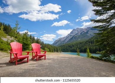 Two Bright Red Adirondack Chairs In Banff National Park, Canada