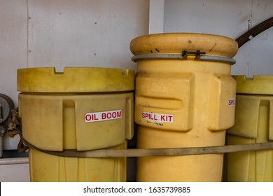 Two Bright Yellow Plastic Bins, Labeled With Oil Boom And Spill Kit Secured On The Deck Of A Canadian Ferry Boat. Looking Old And Dirty.