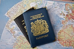 
Two British Passports Overlapping On A Map Of The World