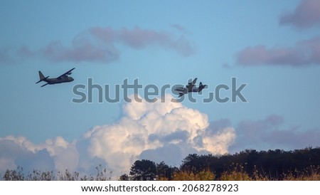 Two British RAF Lockheed Martin C-130J Hercules aircraft on military exercise cargo parachute drop run over Salisbury Plain Training Area, UK