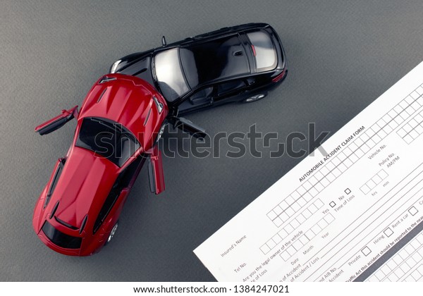 two broken toy cars and car\
insurance document. rental car insurance concept. gray\
background