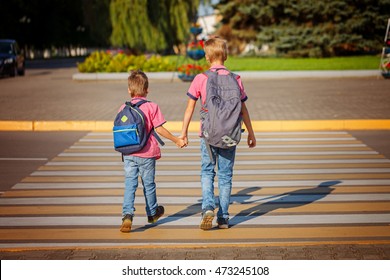 Two brothers with backpack walking, holding on warm day  on the road. Back view. - Powered by Shutterstock