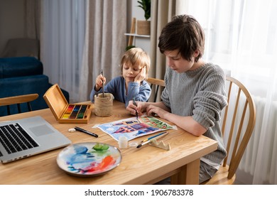 Two brothers drawing at home during lockdown, using online lesson on laptop. Online education with wireless technologies during quarantine and self-isolation - Shutterstock ID 1906783378