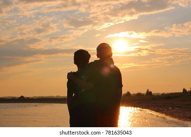 Two Brothers Enjoying The Sunset At Salisbury Beach.