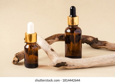 Two Brown Bottles Of Cosmetics On A Beige Background. Natural Driftwood Decor. Front View.