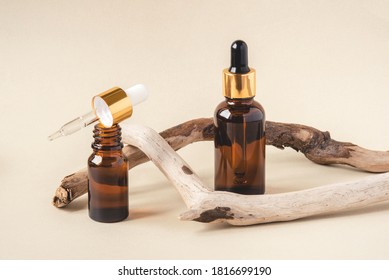 Two Brown Bottles Of Cosmetics On A Beige Background. Natural Driftwood Decor. Front View.