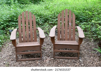 Two Brown Lawn Chairs In A Garden