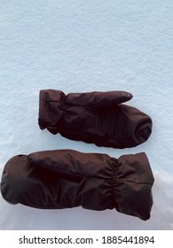 Two Brown Mittens In The Snow