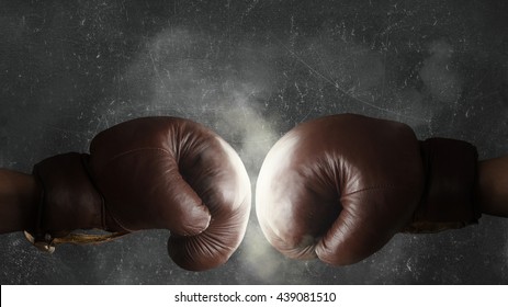 Two Brown Old Boxing Gloves Hit Together