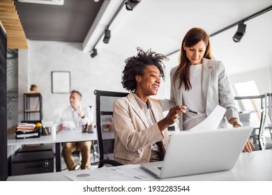 Two brunette business woman, talking, advising each other. - Shutterstock ID 1932283544