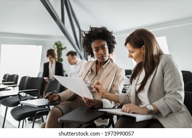 Two brunette females having conversation about their job. - Shutterstock ID 1973990057