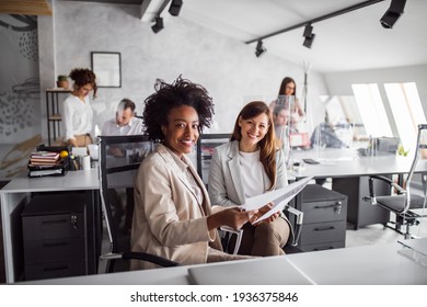 Two brunette females looking at camera, while other people taking break, talking to each other. - Shutterstock ID 1936375846
