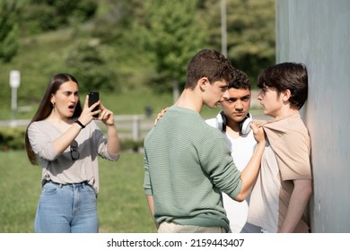 Two Bullies Menacing Teenager Boy And Girl Filming On Phone. Cyber Bullying And Violence Concept.